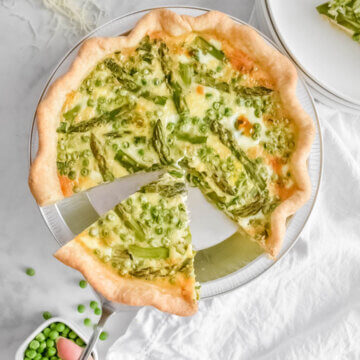 A slice of Asparagus and Pea Quiche being served.