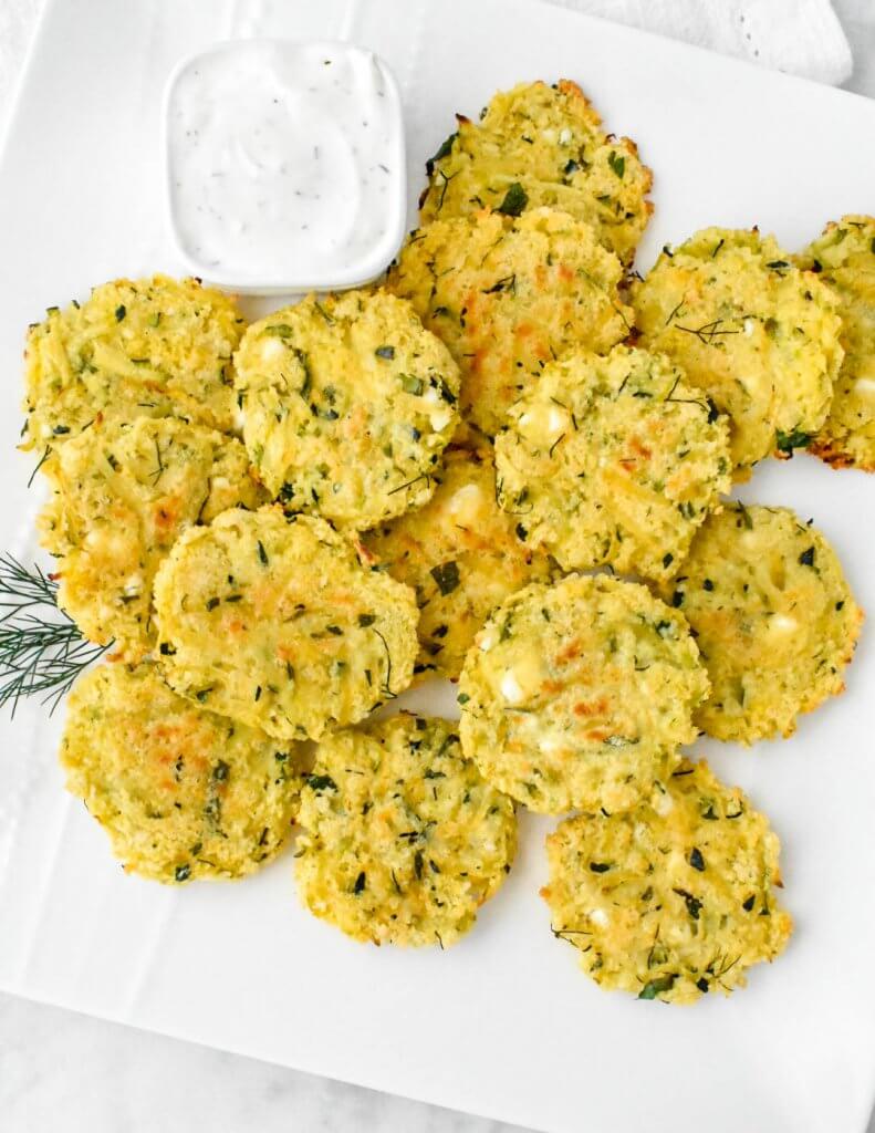 Baked Zucchini Feta Fritters on a platter with dip
