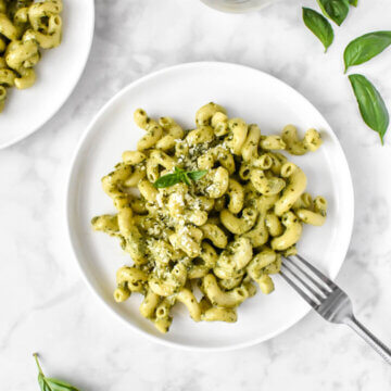 plated creamy pesto pasta topped with fresh basil