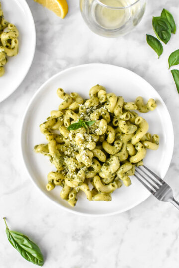 plated creamy pesto pasta topped with fresh basil