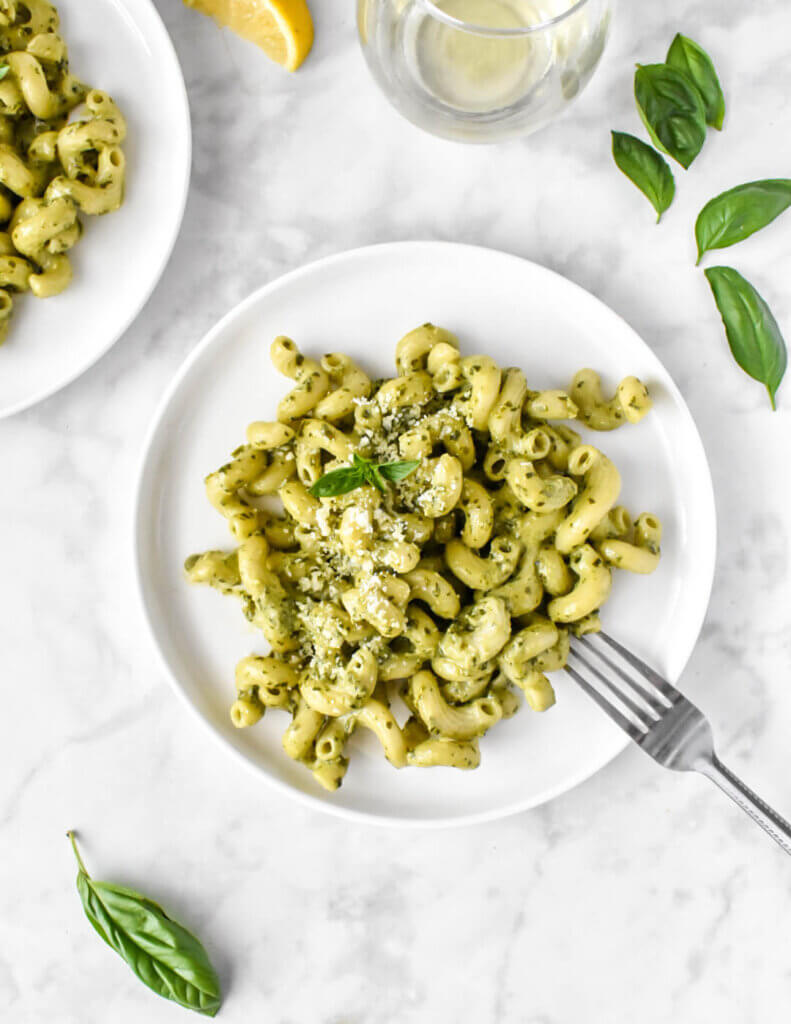 plated creamy pesto pasta topped with fresh basil