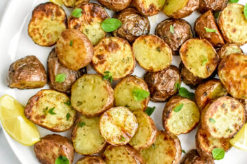 crispy air fryer Greek potatoes on a platter with lemon wedges