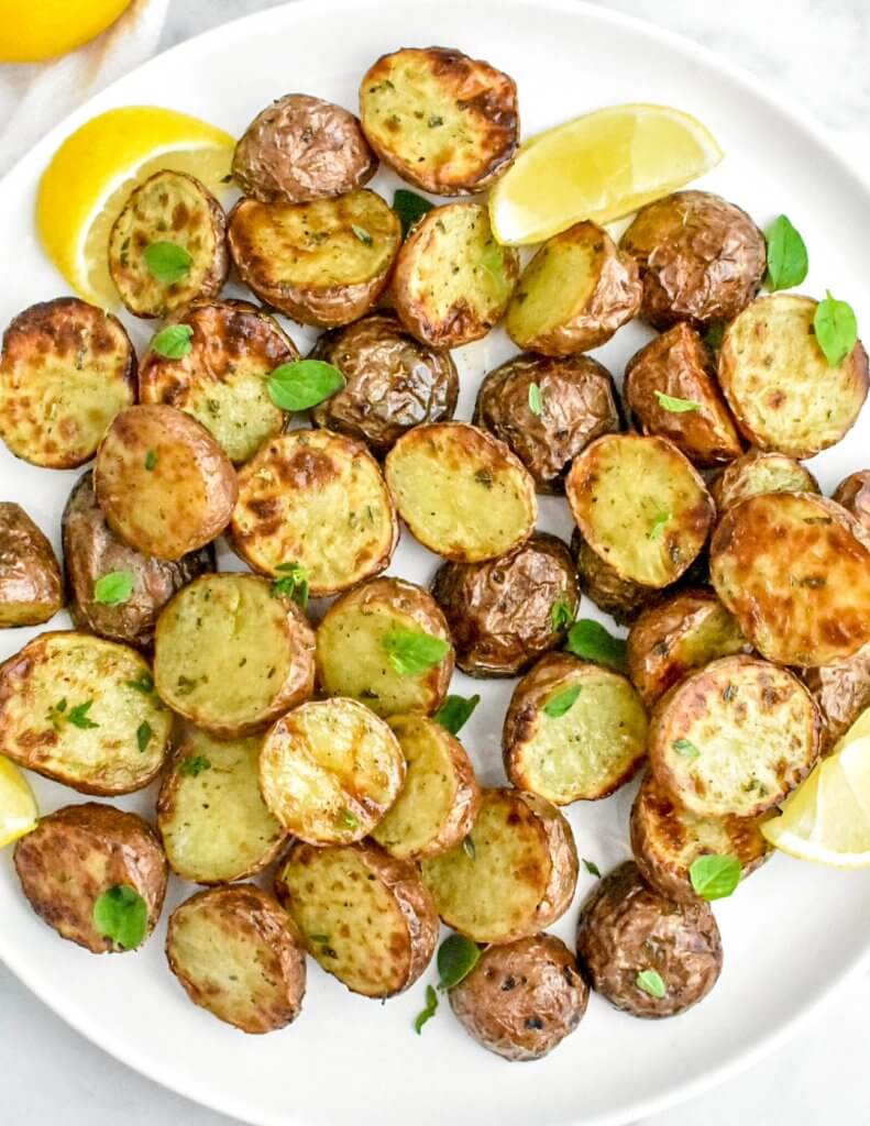 air fryer potatoes on a platter with lemon wedges