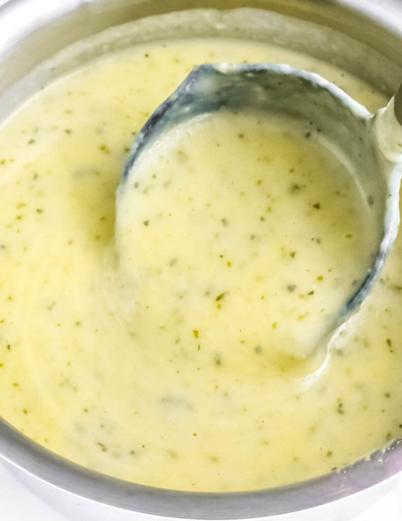 ladel full of creamy zucchini soup