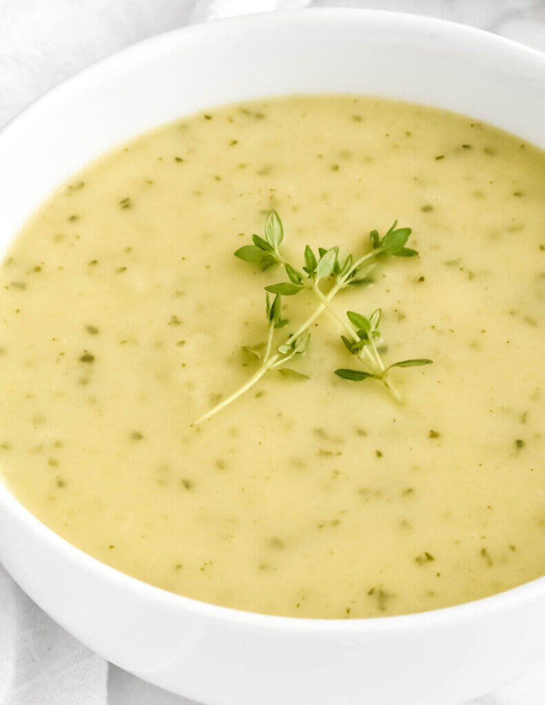 Creamy Zucchini Soup topped with fresh thyme sprigs