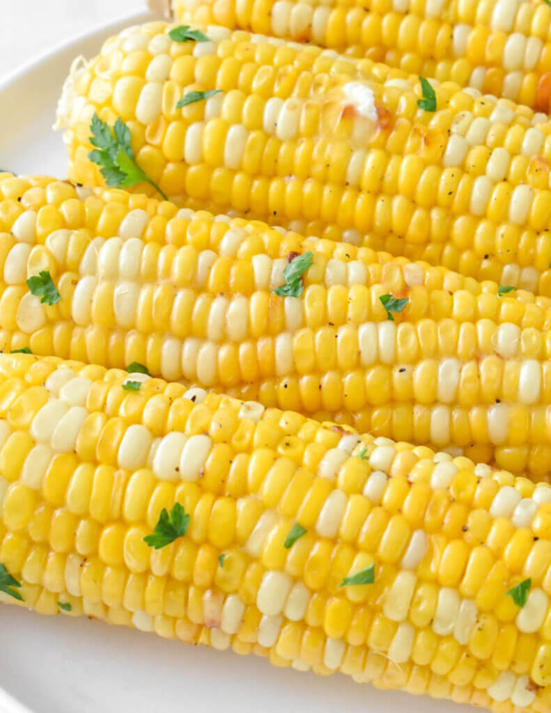 roasted corn on the cob sprinkled with fresh parsley