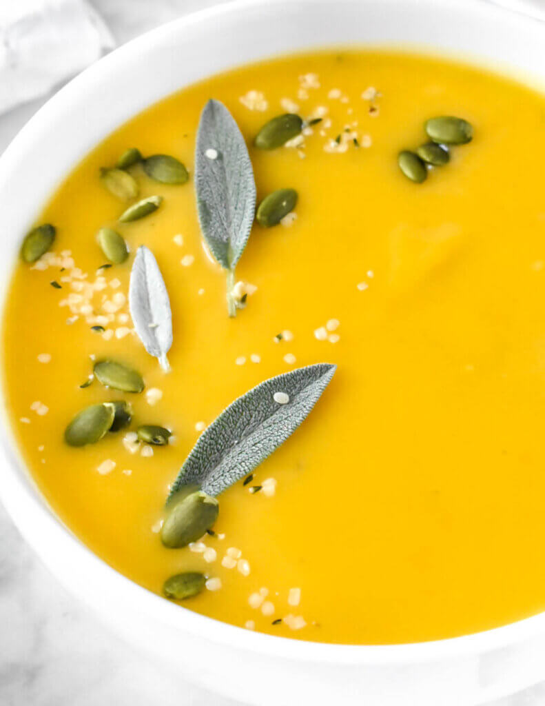 Bowl of Roasted Butternut Squash Soup topped with sage and pumpkin seeds