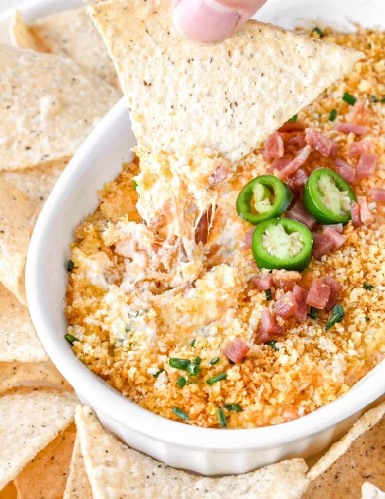 Jalapeno Popper Dip with Bacon scooped up with a tortilla chip