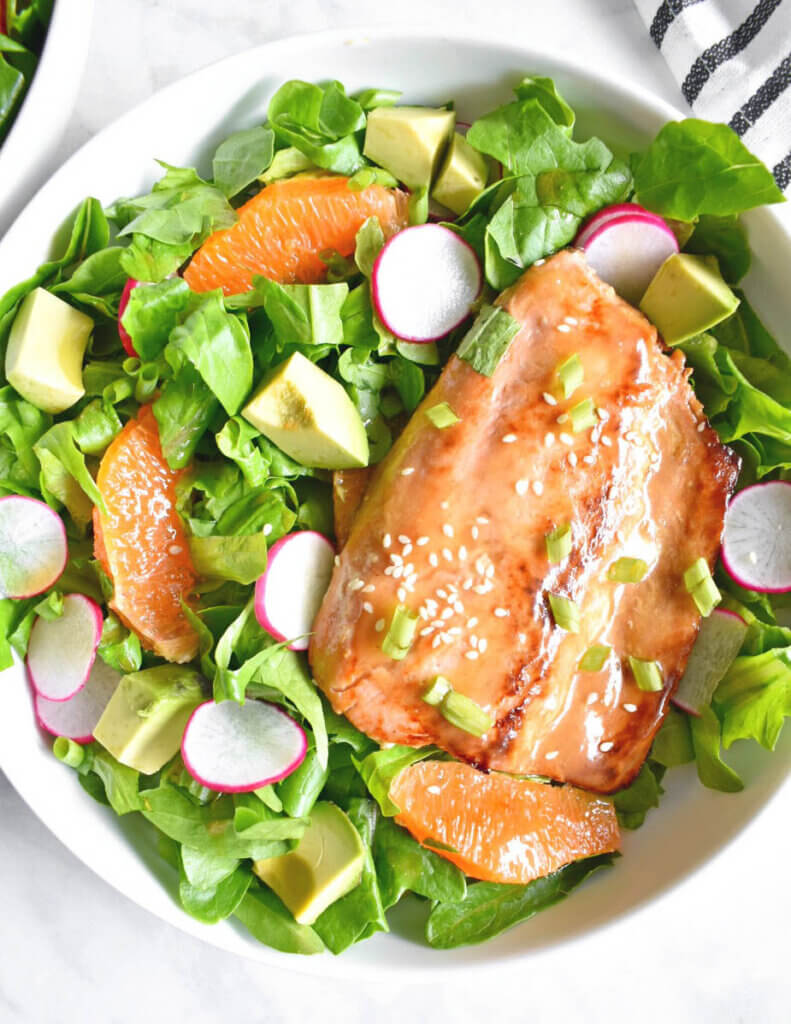 Salad topped with glazed citrus soy salmon