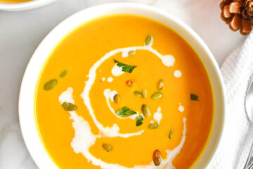 Bowl of Creamy Pumpkin Soup drizzled with coconut milk