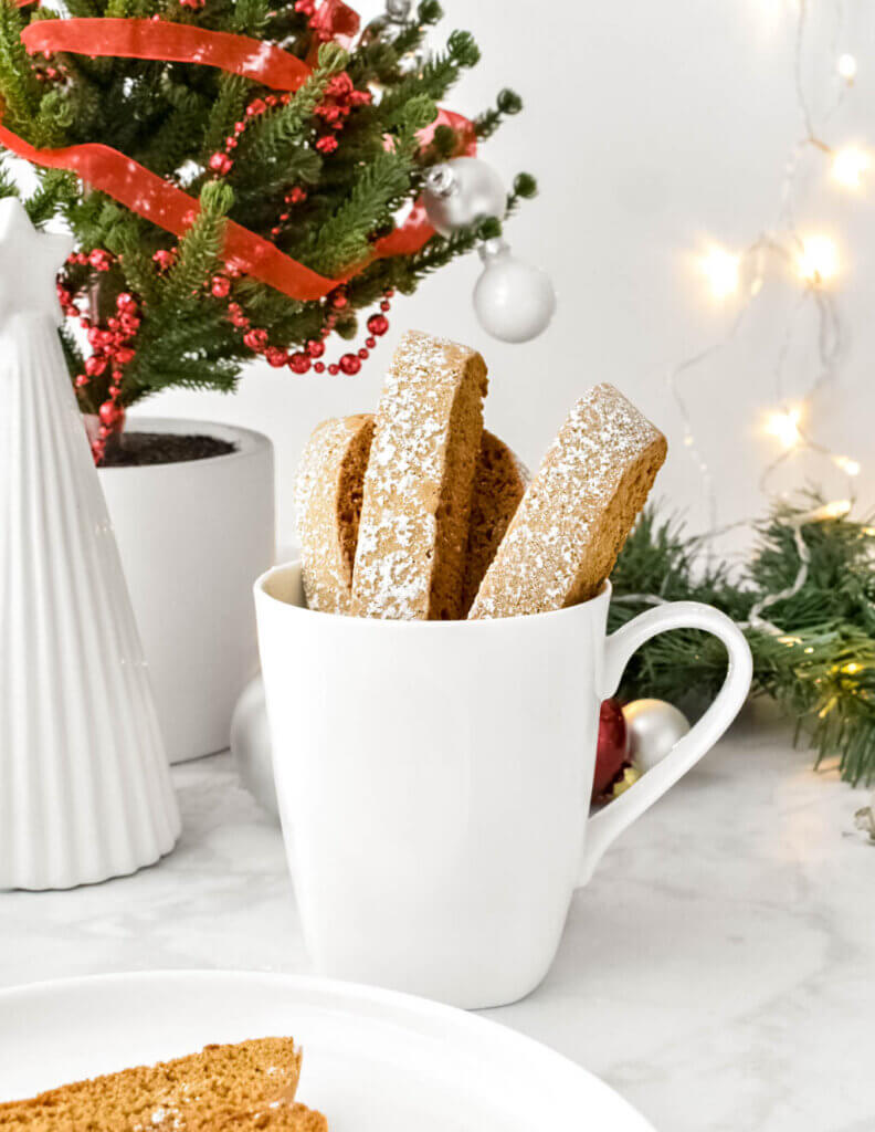 Mug filled with gingerbread biscotti on a Christmas table