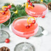 Holiday cocktails garnished with fresh cranberries and orange twirls