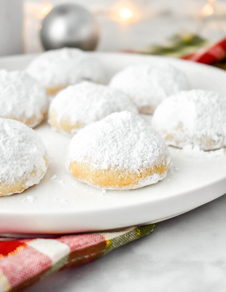 Plate of Kourabiedes cookies topped with icing sugar