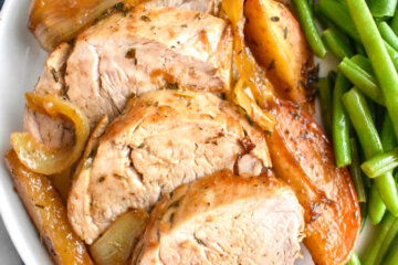 Plate of sliced Pork Tenderloin with carmelized apples, onions and green beans.