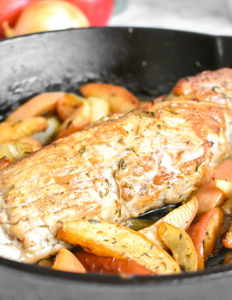 Closeup of a cooked pork tenderloin with apples.