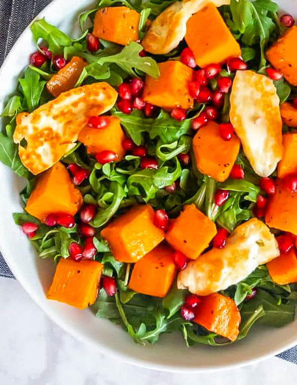 Arugula salad with lots of roasted butternut squash, halloumi cheese and pomegranate arils