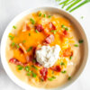 Bowl of Slow Cooker Baked Potato Soup topped with sour cream