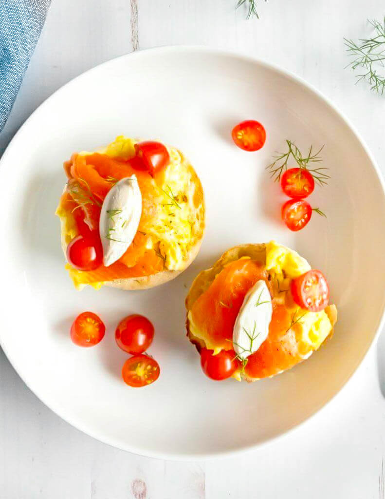 English muffins topped with smoked salmon, scrambled eggs and cherry tomatoes