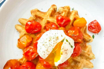Zucchini Oat Waffle topped with blistered cherry tomatoes and a poached egg