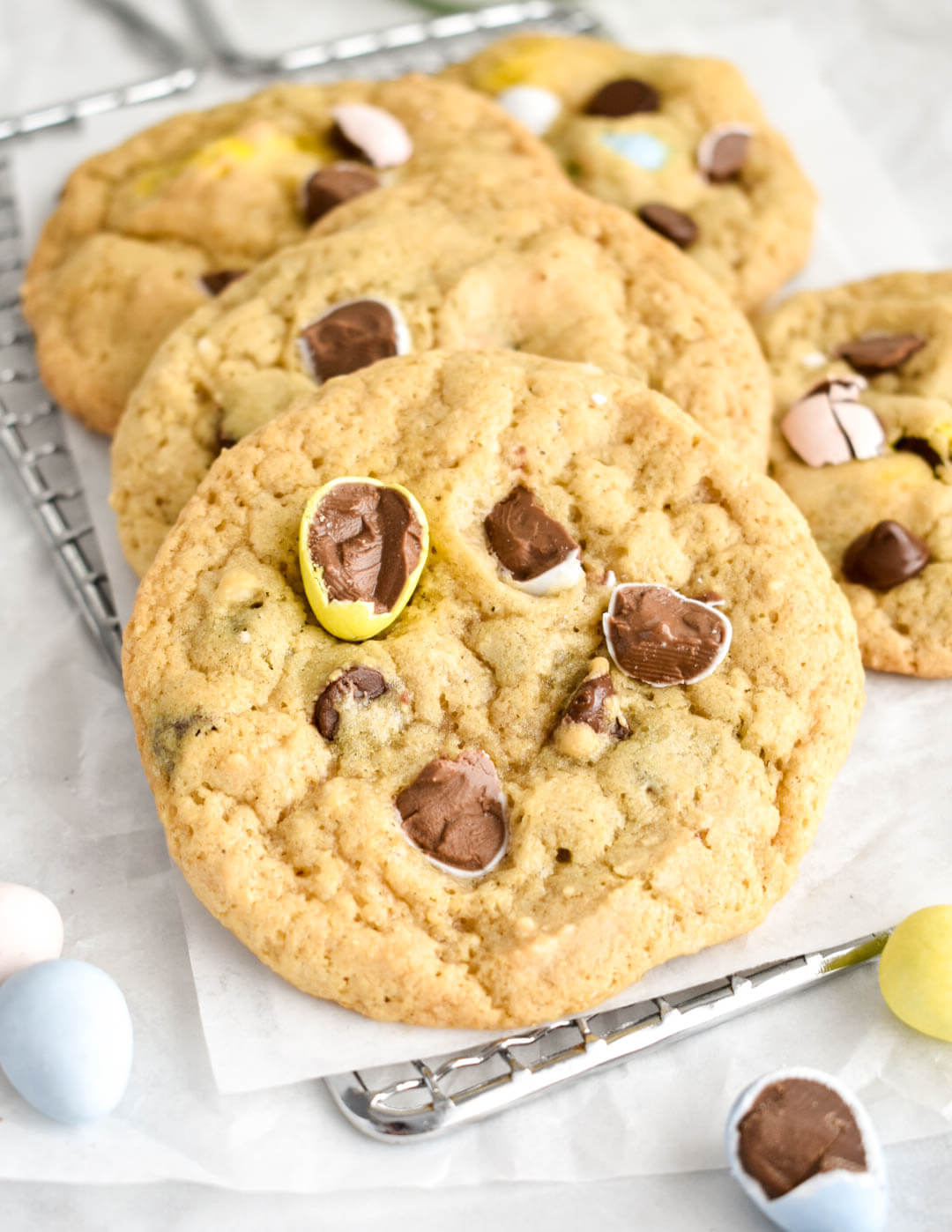 Easter Chocolate Chip Cookies on a cooling rack lined set on parchment paper.