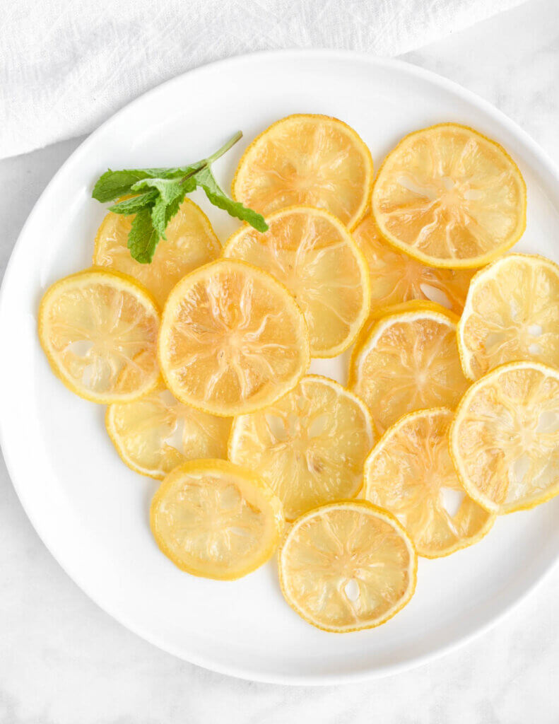 Preserved lemon slices on a white platter with mint garnish.