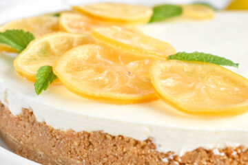 No Bake Lemon Cheesecake topped with candied lemon slices and mint leaves.