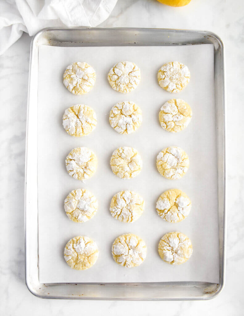 A baked tray of lemon crinkle cookies.