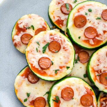 Zucchini Pizza Bites topped with pepperoni on a blue platter.