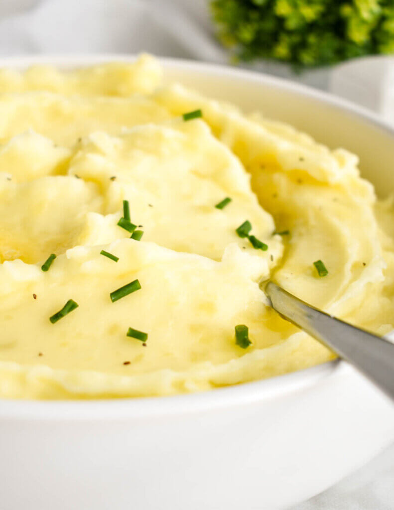 Closeup of fluffy whipped potatoes sprinkled with chives.