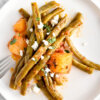 Slow Cooker Greek Green Beans on a plate topped with crumbled feta.