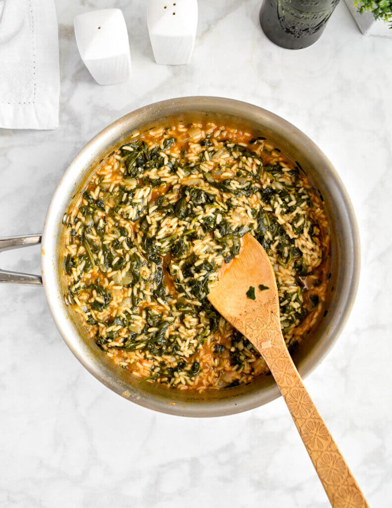 Spanakorizo (Greek Spinach and Rice) in a skillet set on a grey marble countertop.