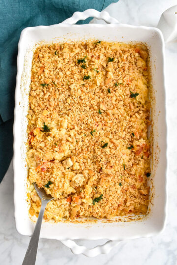 Creamy Chicken and Rice Casserole in a white baking dish set on a grey marble counter next to a teal linen napkin.