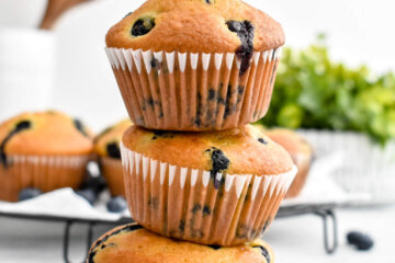 Three Buttermilk Blueberry Muffins stacked on top of each other.