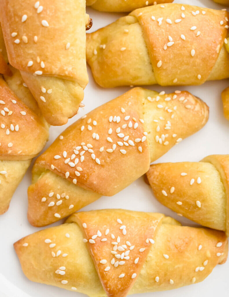 Closeup of tiropites made with dough and sprinkled with sesame seeds.