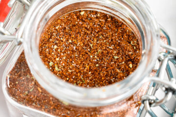 Homemade taco seasoning in a small glass spice jar labelled "Taco Seasoning".