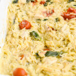 Closeup of Easy Boursin Chicken Orzo Bake in a white baking dish.