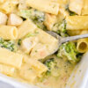 Closeup of Easy Chicken and Broccoli Pasta Bake being scooped from the baking dish.