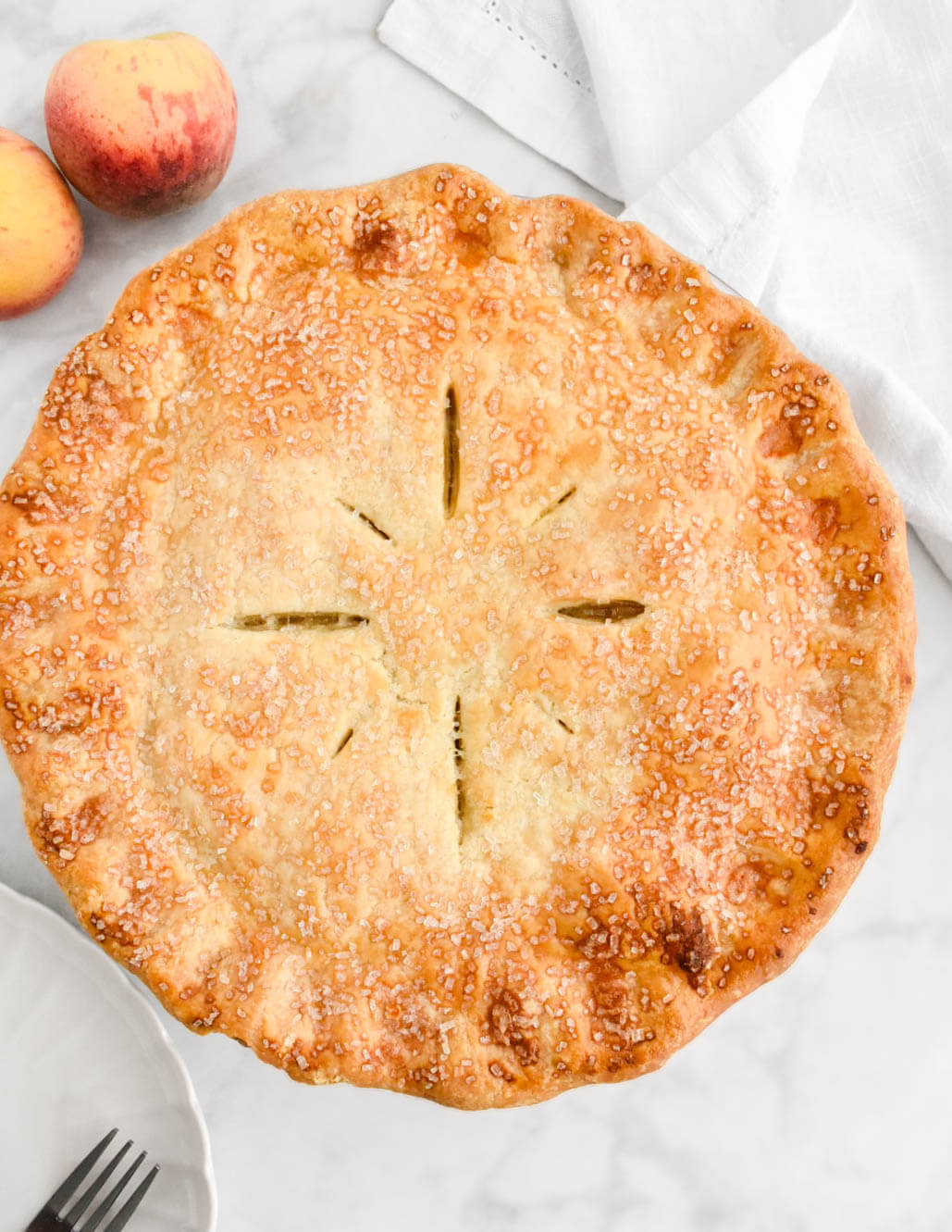 Top view of a peach pie, baked golden-brown.