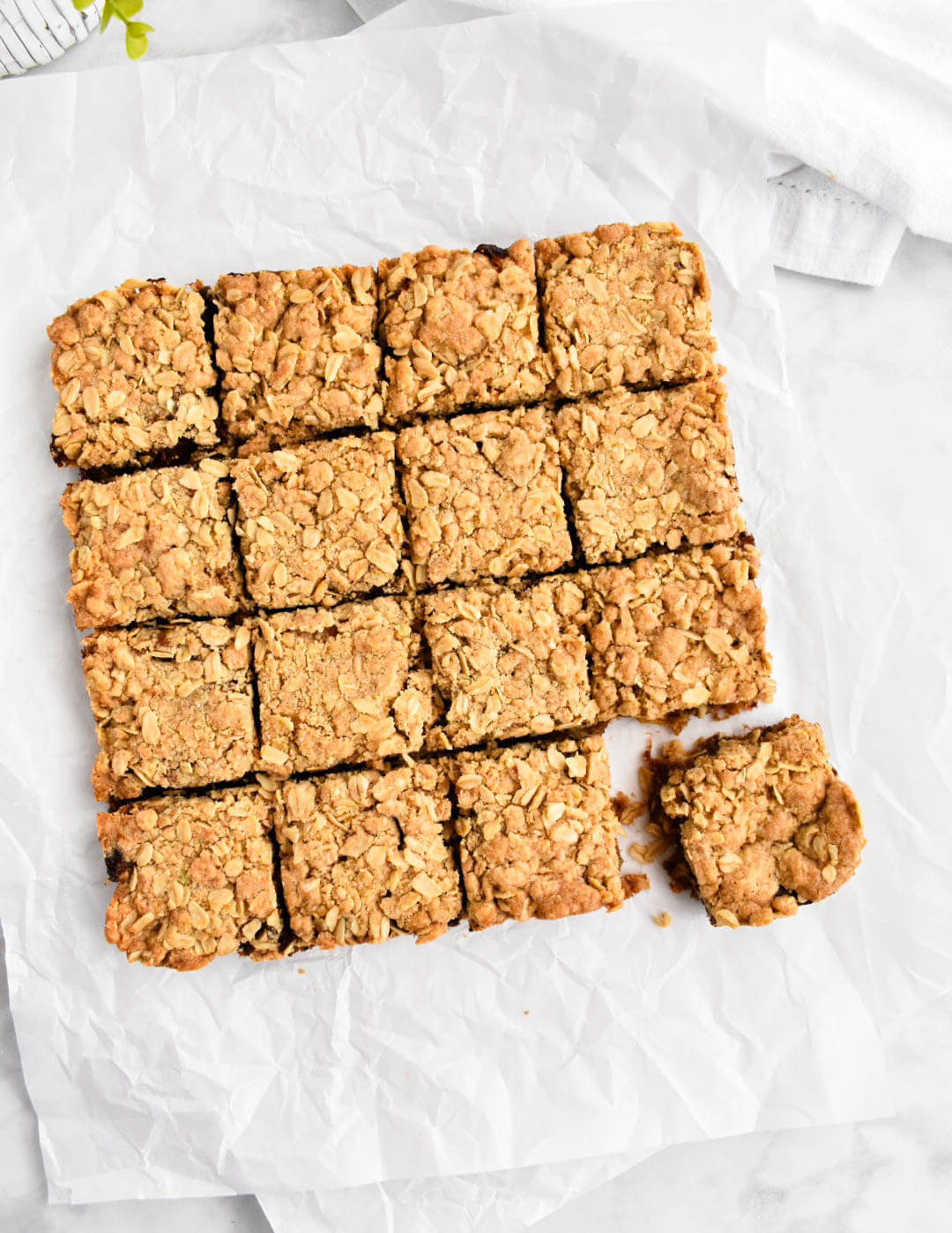 Date squares cut into small squares on white parchment paper.