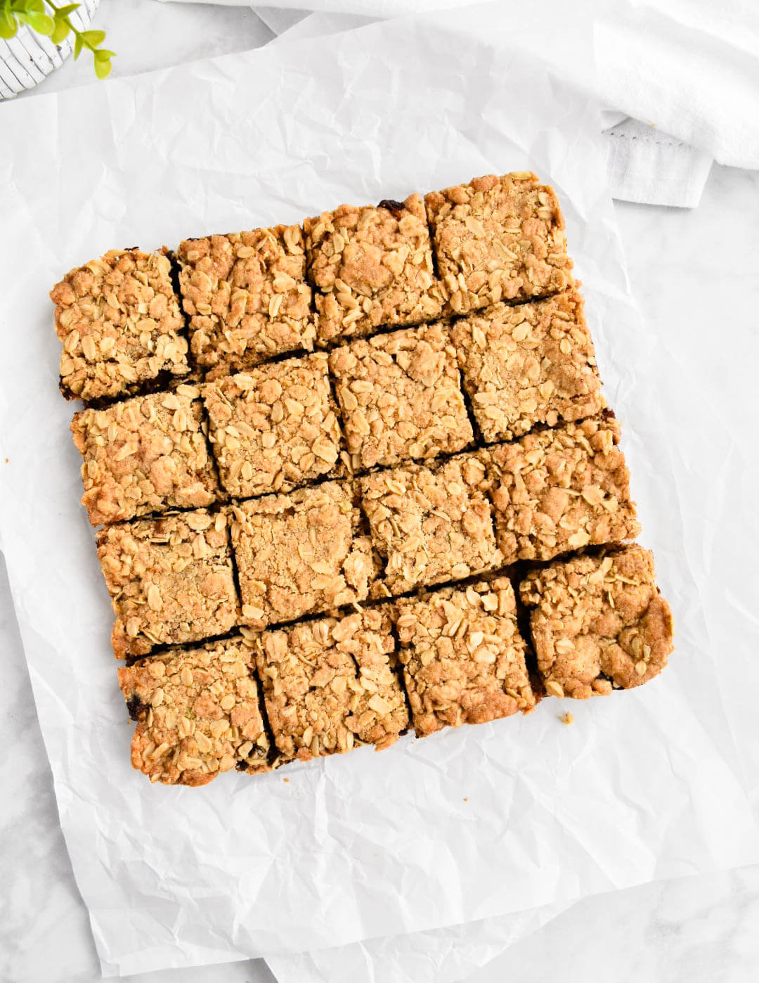 Date squares cut into small squares on white parchment paper.
