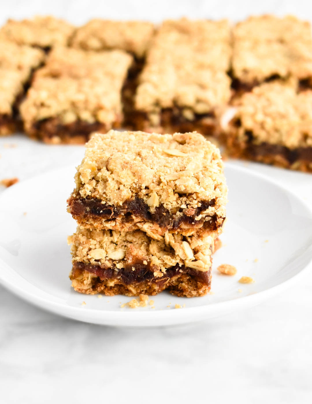 Two date squares stacked on each other on a dessert plate.