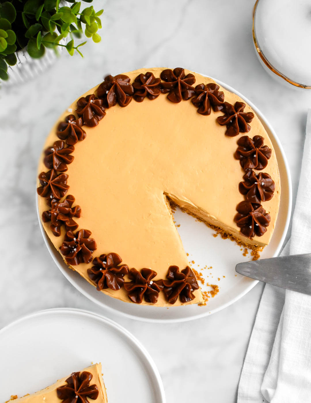 Top view of a sliced dulce de leche cheesecake decorated with a piped dulce de leche border.