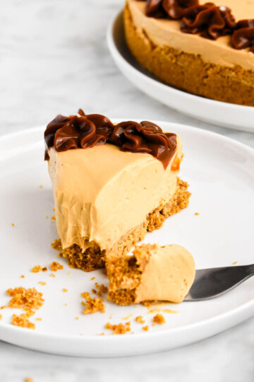 A slice of dulce de leche cheesecake with a forkful of cheesecake broken away.