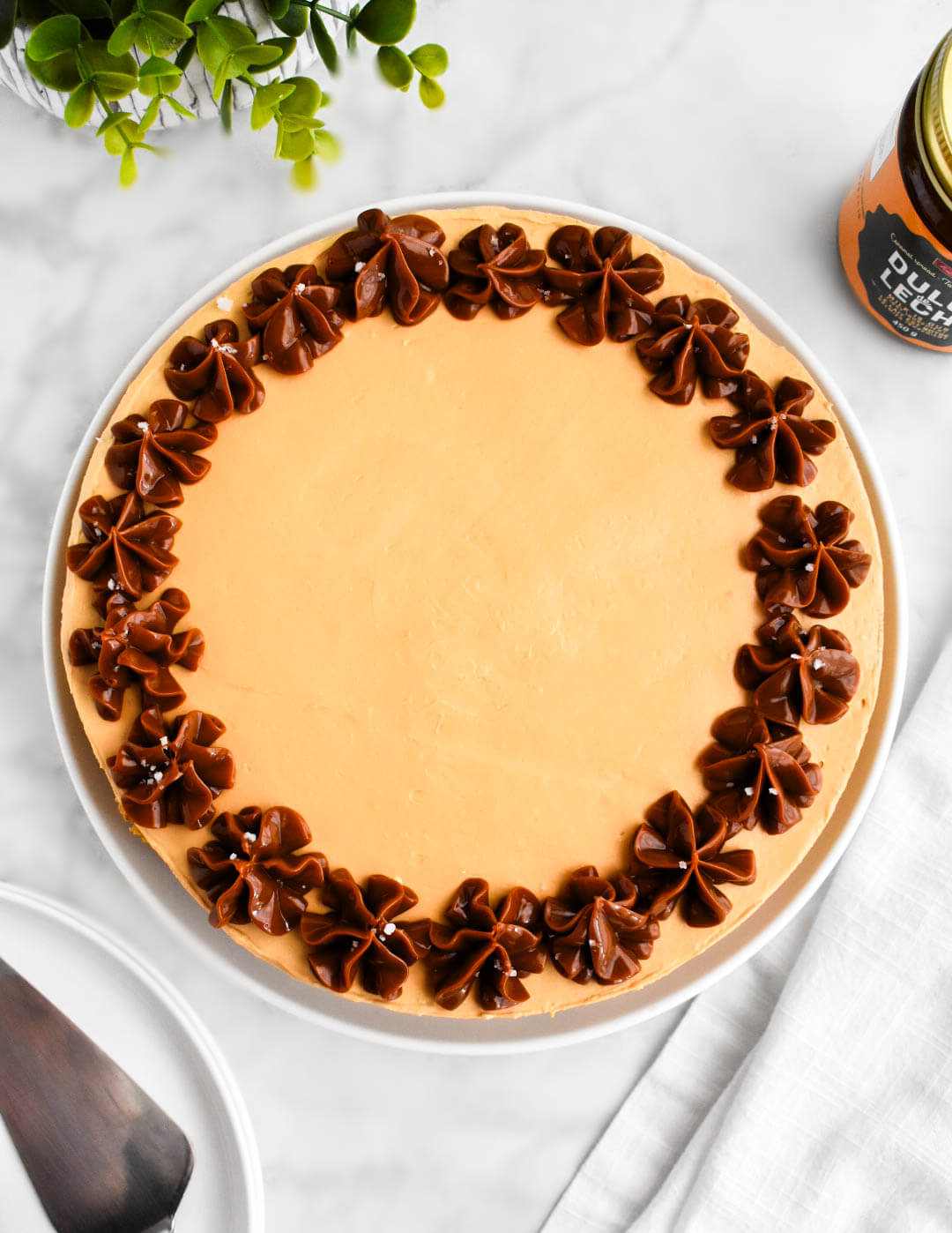 Top view of a dulce de leche cheesecake decorated with a piped dulce de leche border.