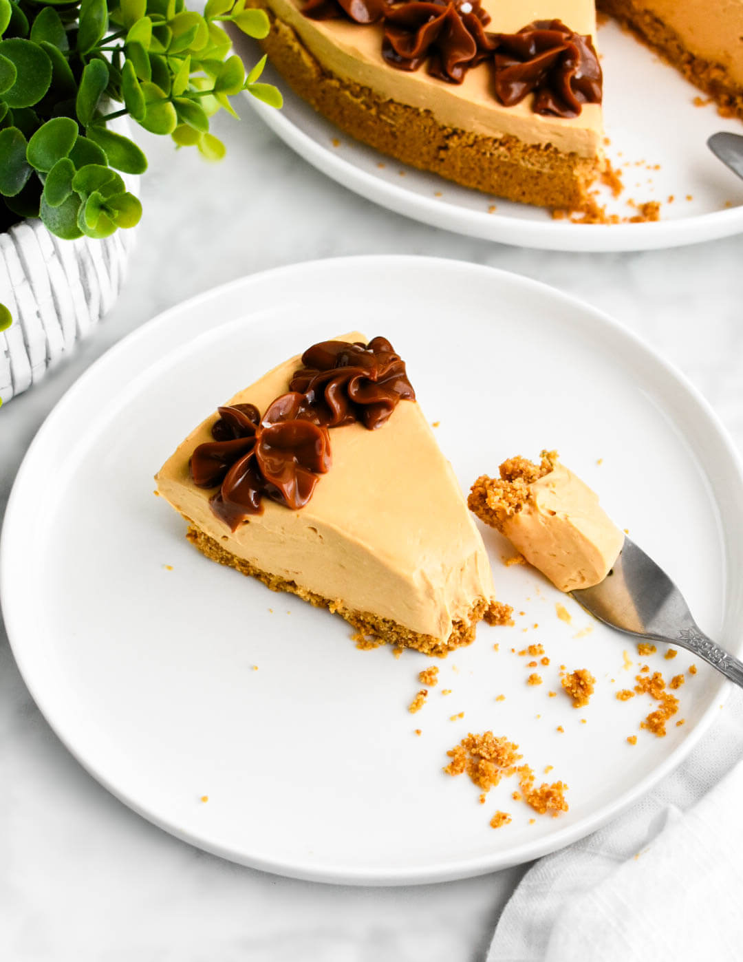 A slice of dulce de leche cheesecake with a bite of cheesecake on the fork.