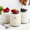 3 jars of overnight oats topped with berries and granola.