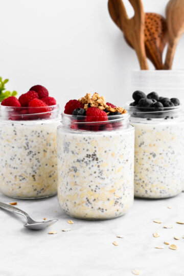 3 jars of overnight oats topped with berries and granola.