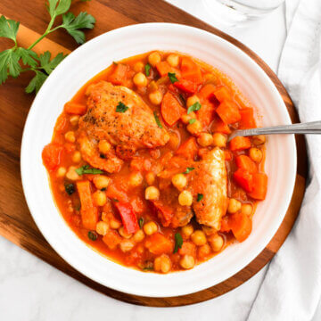 A bowl of Greek chicken and chickpea stew sprinkled with parsley.